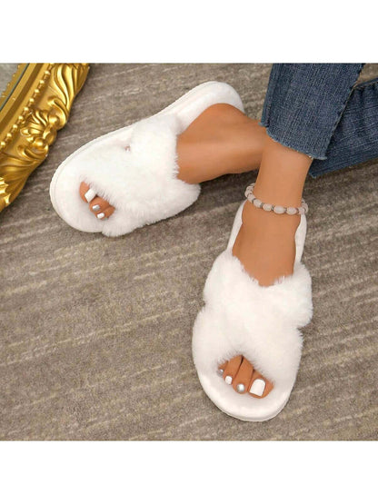 Close-up of white Axon Cloud-Soft cross strap fur slippers worn with denim jeans and a stylish anklet.